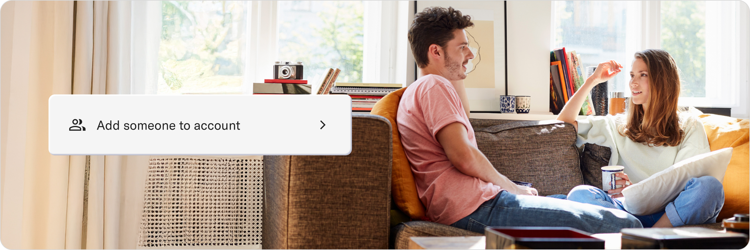 Two people chatting on a sofa with coffee